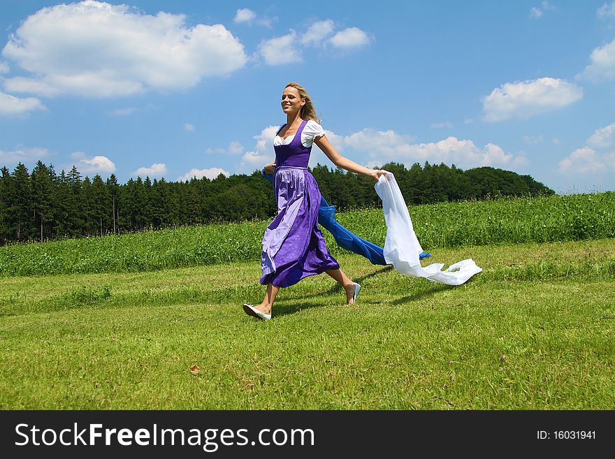 Beautiful bavarian Woman running with Cloths