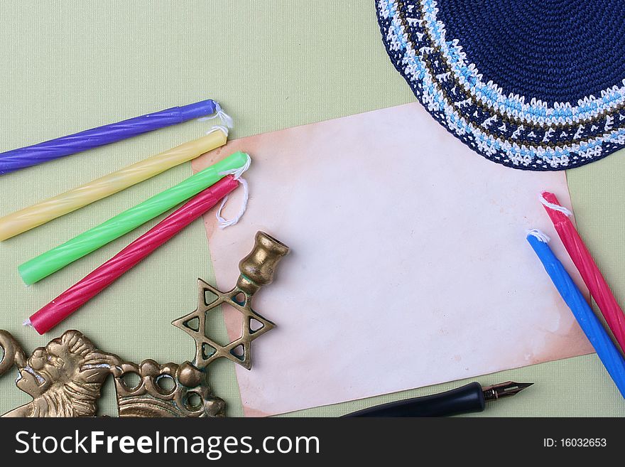 Menorah and a blue kippah next to an old piece of paper. Add your text to the paper. Menorah and a blue kippah next to an old piece of paper. Add your text to the paper.