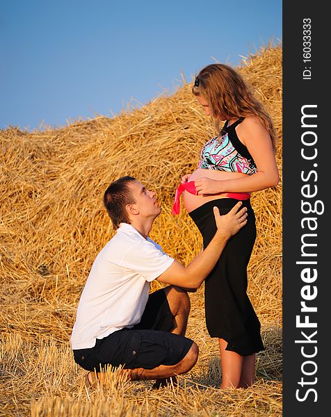 The guy embraces the pregnant girl with a gift in a stomach. The guy embraces the pregnant girl with a gift in a stomach