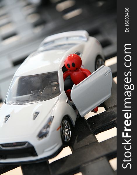 A happy red smiley character jumping in a white sports car for a spin. A happy red smiley character jumping in a white sports car for a spin.