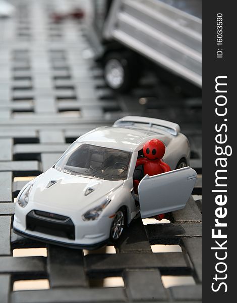 A red smiley face driver getting out of his car with a truck in the background. A red smiley face driver getting out of his car with a truck in the background.