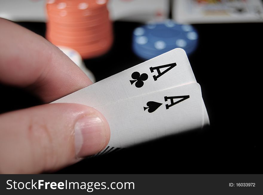 A Pair of Aces on a Black background with white red and blue Poker chips. A Pair of Aces on a Black background with white red and blue Poker chips.