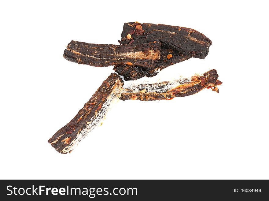 A detailed close-up studio shot of homemade strips of spicy beef jerky on an isolated white background. A detailed close-up studio shot of homemade strips of spicy beef jerky on an isolated white background.
