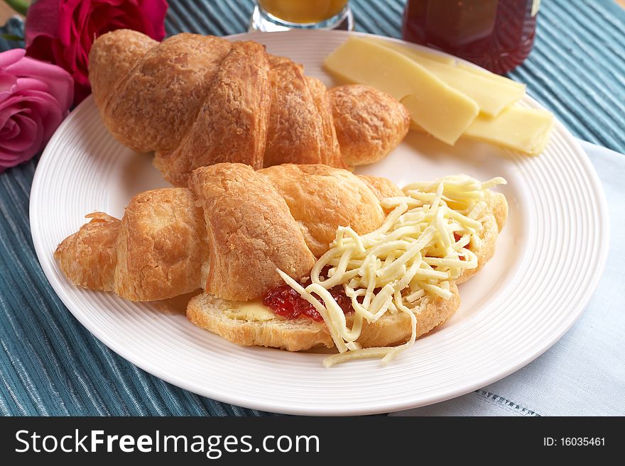 Breakfast plate with freshly baked croissants filled with jam and grated mozzarella cheese. Breakfast plate with freshly baked croissants filled with jam and grated mozzarella cheese