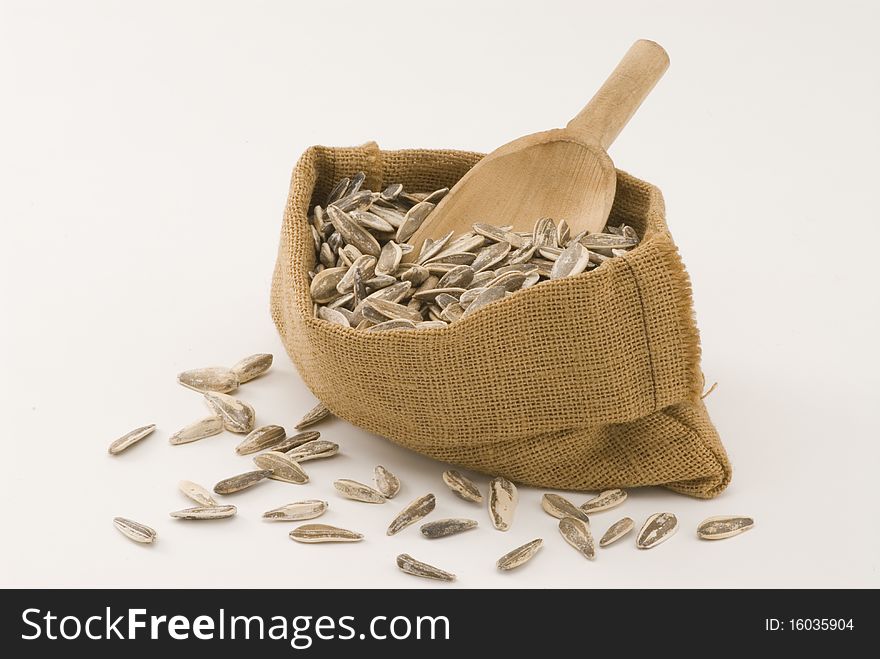 Dried sunflower seeds in a sack. White background. Dried sunflower seeds in a sack. White background.