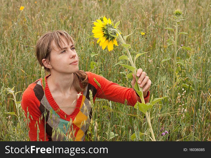 Girl with sunflower looking to it