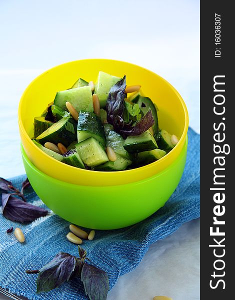 Cucumber salad with colored cups on the blue napkin