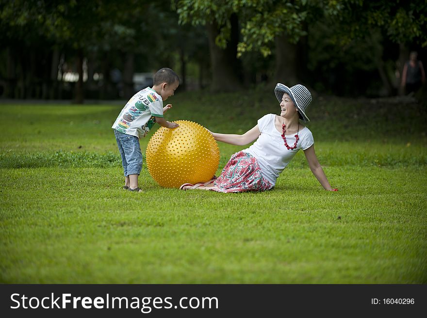 Mother and son in grass and play ball