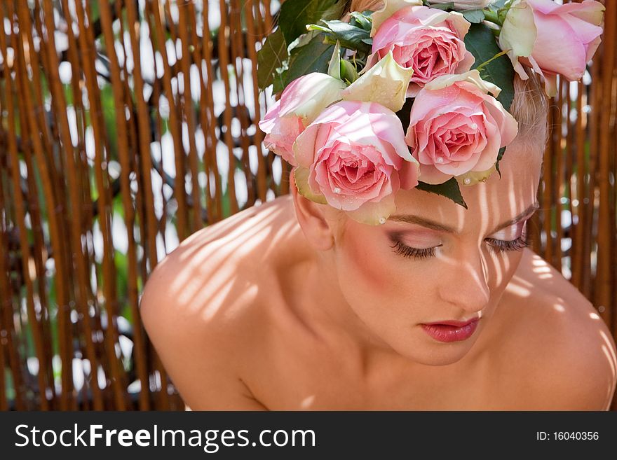 Portrait of beautiful blonde with a wreath of flowers on her head on the grey background. Portrait of beautiful blonde with a wreath of flowers on her head on the grey background