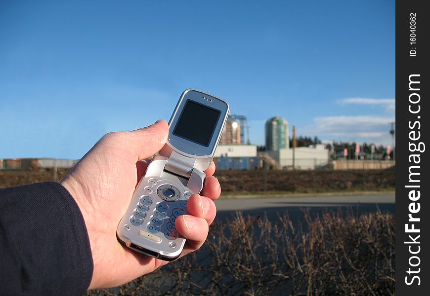 Mobile phone held by hand with a clear blue sky in the background. Mobile phone held by hand with a clear blue sky in the background.