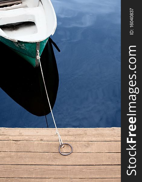 Green boat on the water near the pier