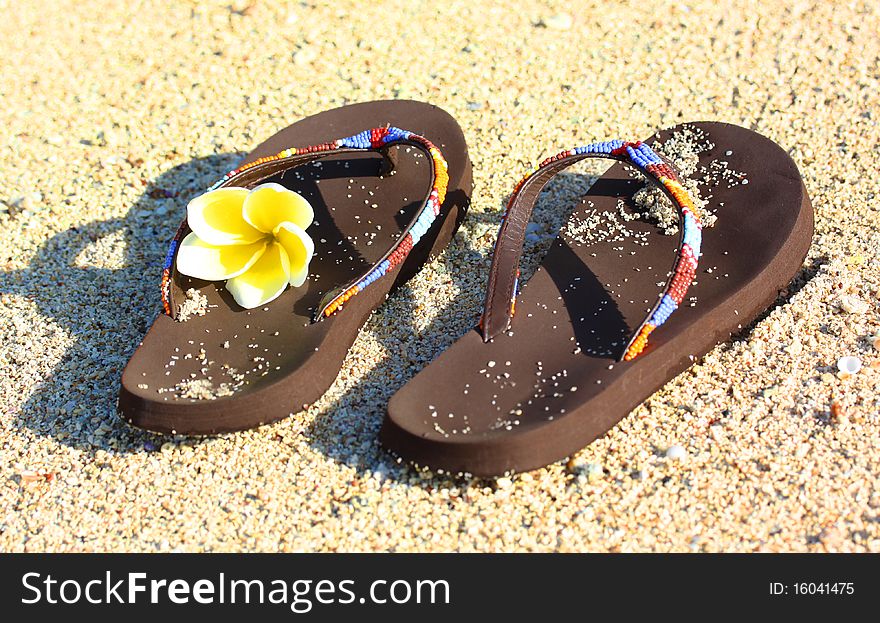 Plumeria and Summer Flip Flop Sandals on a Sand Background. Plumeria and Summer Flip Flop Sandals on a Sand Background.