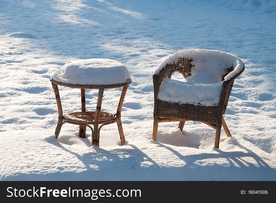 Garden furniture under the snow sunny day