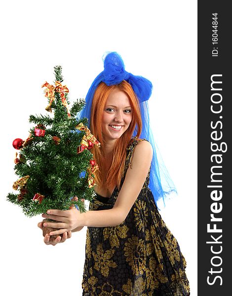 The young beautiful girl in a dress holds a Christmas tree on is isolated a background