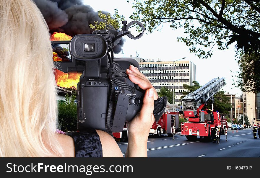 Woman videographer recording big fire in the city. Woman videographer recording big fire in the city