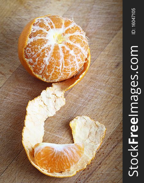 Tangerine with peeled on the wooden background. Tangerine with peeled on the wooden background