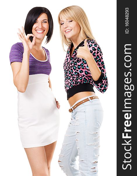 Two young beautiful woman showing Thumbs up and ''Ok'' signs. Isolated on white background. Two young beautiful woman showing Thumbs up and ''Ok'' signs. Isolated on white background