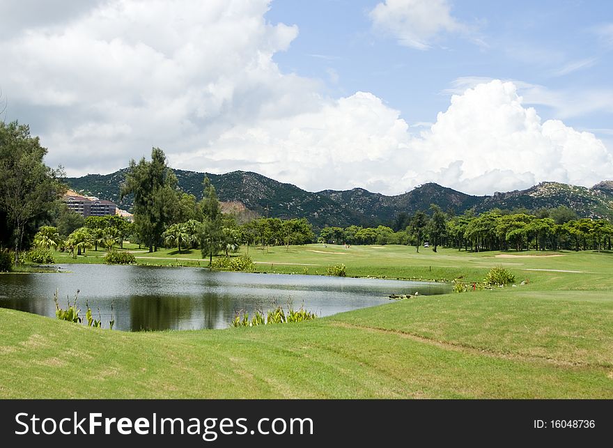 Golf course,lake,mountain and cloudscape