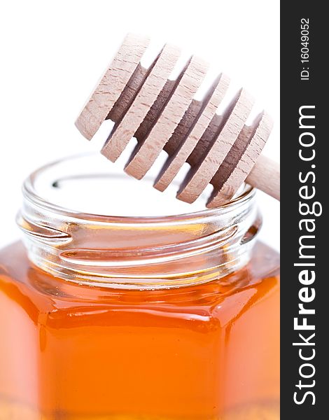 Detail of a jar of honey and a wooden dipper. Detail of a jar of honey and a wooden dipper