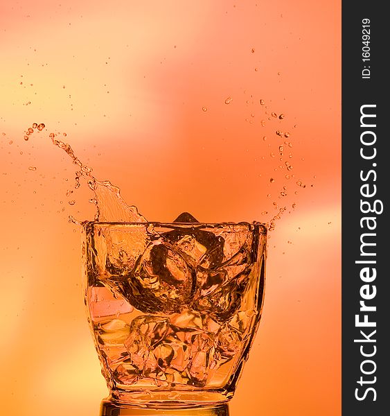 Whisky and ice. Splashing scotch on brown background. Whisky and ice. Splashing scotch on brown background