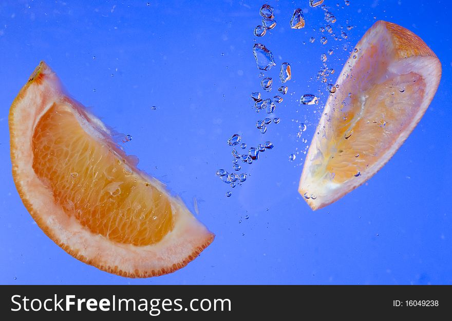 Fresh orange in the blue water. Fresh orange in the blue water