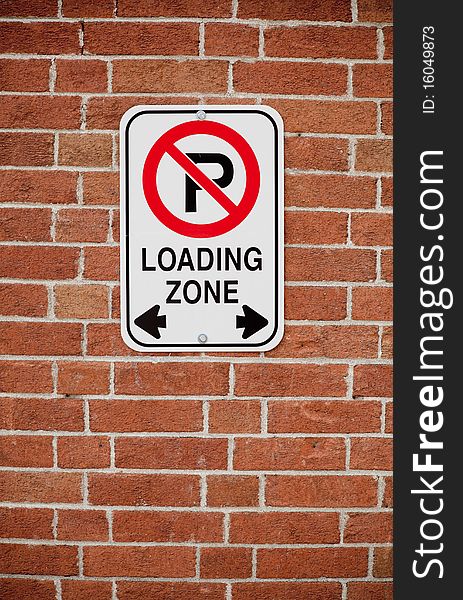 Close up of loading zone sign on red brick background, vertical format. Close up of loading zone sign on red brick background, vertical format.