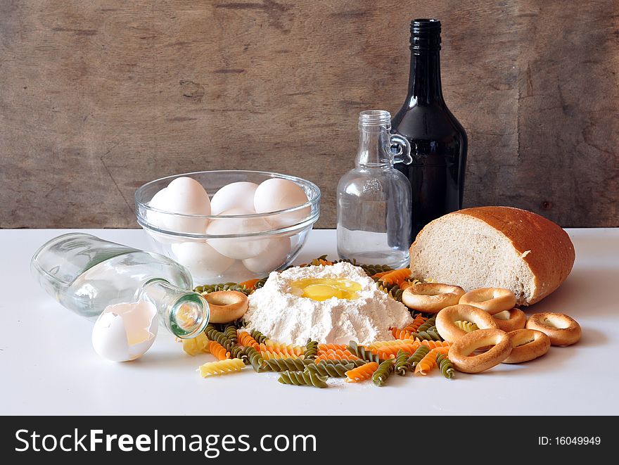 Eggs, flour, bread, bagels, lie on a table, a vermicelli costs two bottles alongside. Eggs, flour, bread, bagels, lie on a table, a vermicelli costs two bottles alongside