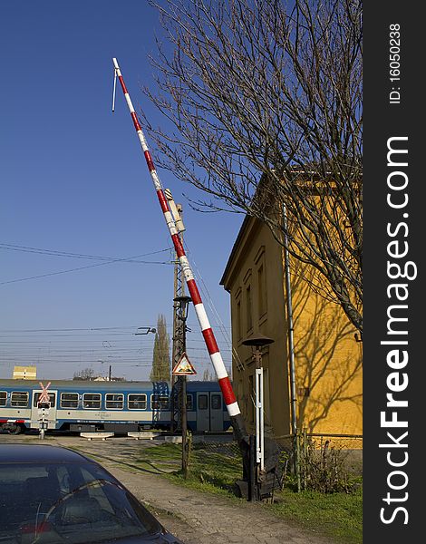 European railroad crossing with passing train and waiting car