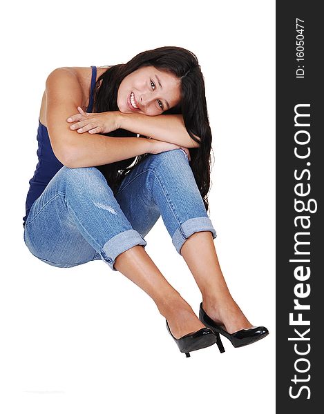 A pretty young woman with long brunette hair and jeans sitting on the floor, smiling into the camera, for white background. A pretty young woman with long brunette hair and jeans sitting on the floor, smiling into the camera, for white background.