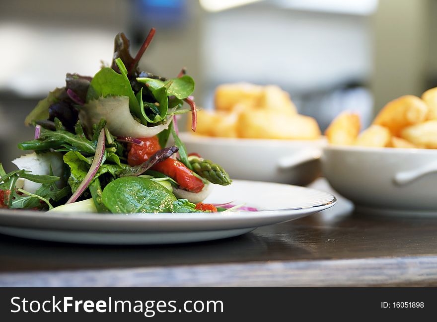 Salad Piled High With Bowls Of Chips