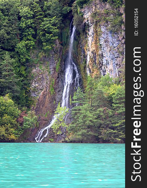 A waterfall cascading down a mountainside into a lake near Interlachen. A waterfall cascading down a mountainside into a lake near Interlachen