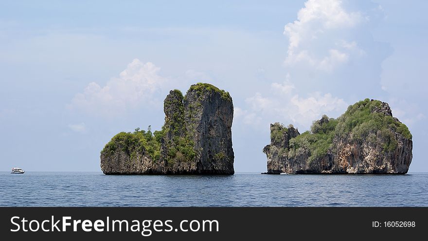 Two islands covered with plants at ocean