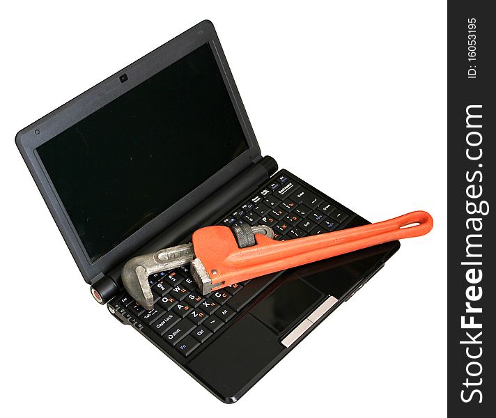Pipe wrench lying on the laptop. Pipe wrench lying on the laptop