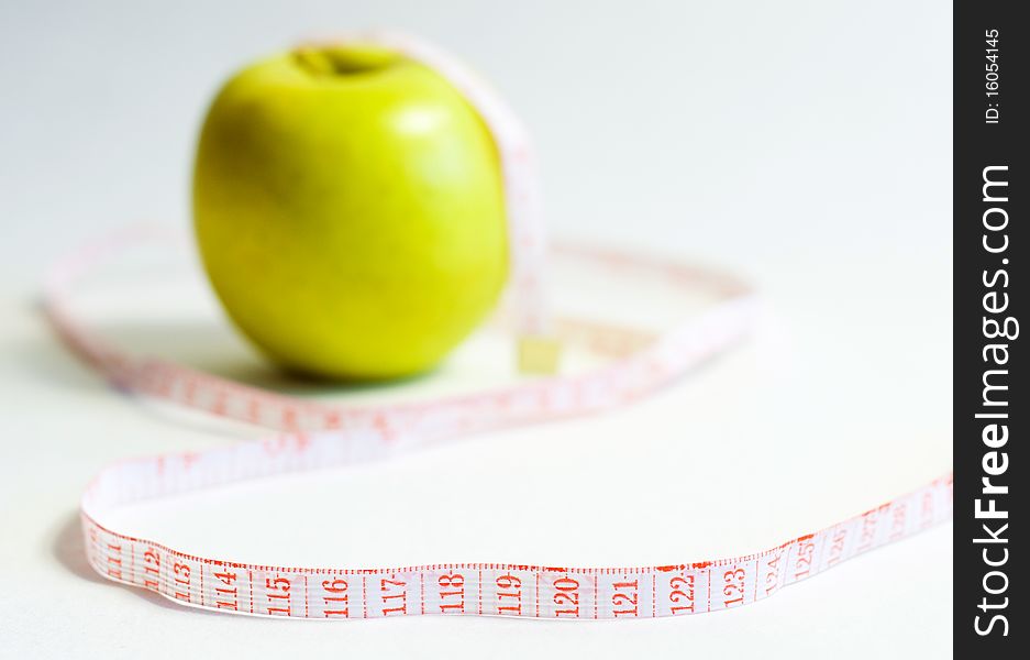 Green apple and measure tape, dieting theme .