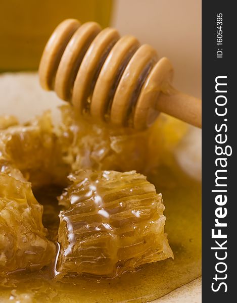 Honeycombs on a plate wooden honey stick. Honeycombs on a plate wooden honey stick