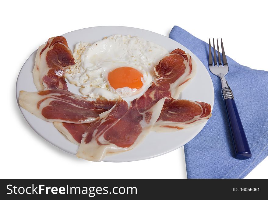 Plate with a fried egg and slices of ham on white background isolated. Plate with a fried egg and slices of ham on white background isolated