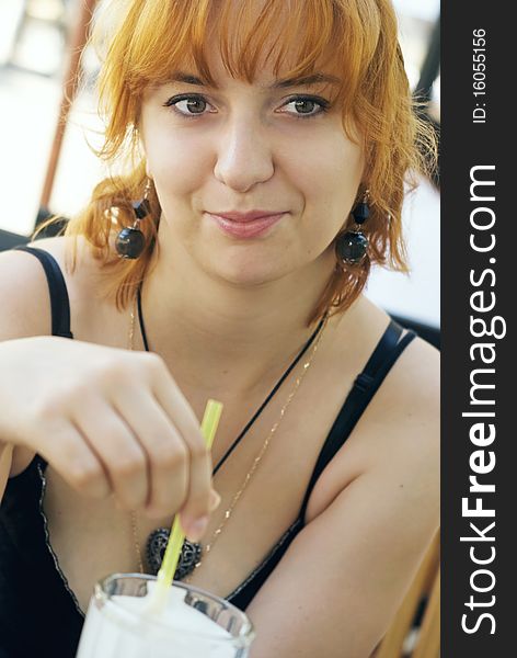 Young red  smilling woman with milk-shake. Young red  smilling woman with milk-shake