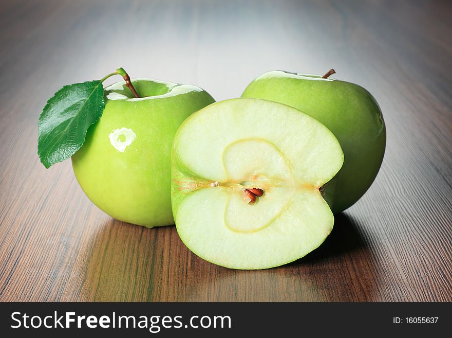 Shot of fresh green apples with green leaf on a table.