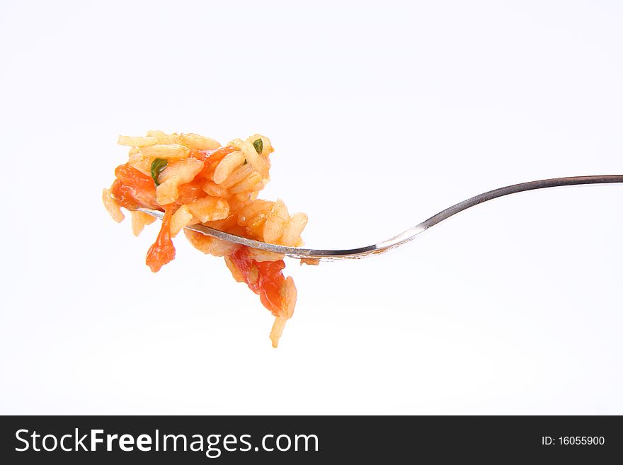 Risotto with tomatoes on a fork on white background