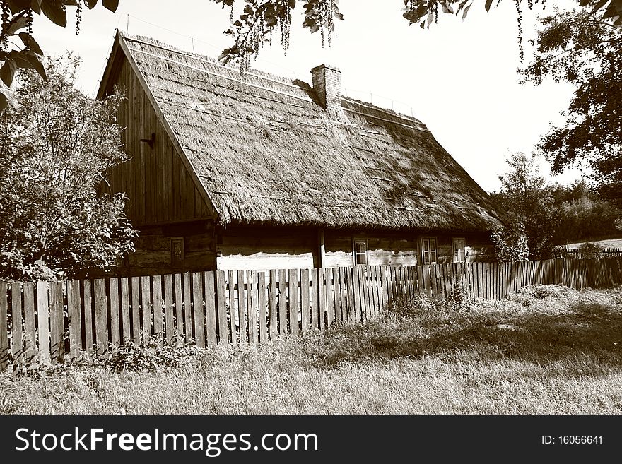 Old thatched cottage surrounded with an old fence