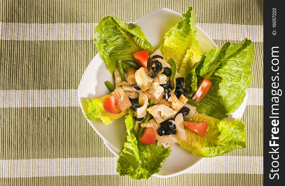 Antipasto salad with lettuce, tomatoes, olives and corn