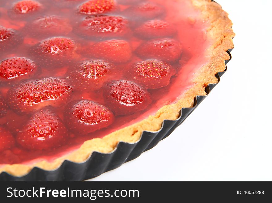 Strawberry Tart in a tart pan on a white background in close up