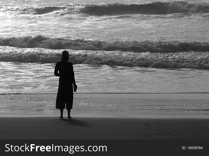 Silhouette of woman on beach next to Pacific Ocean. Silhouette of woman on beach next to Pacific Ocean.