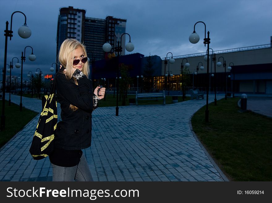 Young beauty posing over night city, evening background. Young beauty posing over night city, evening background