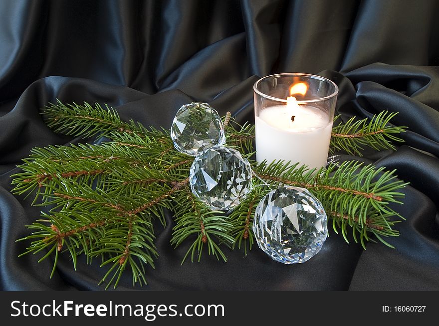 Crystal balls, pine branch and candle on black fabric. Crystal balls, pine branch and candle on black fabric