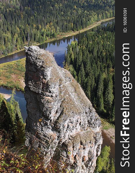 Natural rock against the river and wood