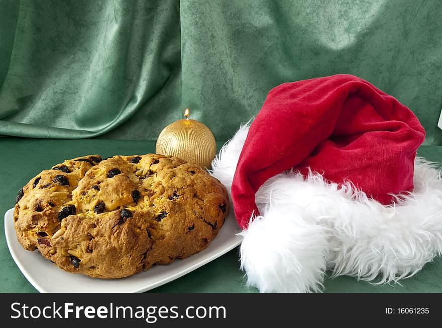 Panettone and Santa Claus hat on green background. Panettone and Santa Claus hat on green background