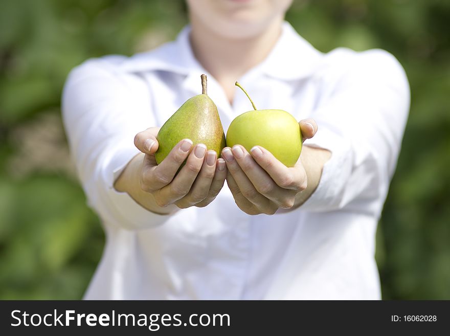 The young woman is holding fruits in hands. The young woman is holding fruits in hands.