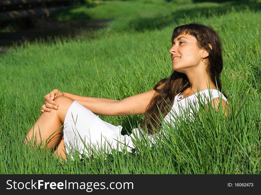 Pretty young woman dreaming on the grass