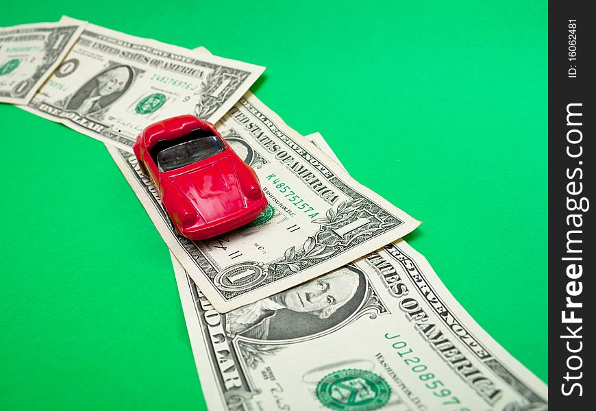 Red toy car on road made from one dollar banknotes. Red toy car on road made from one dollar banknotes.